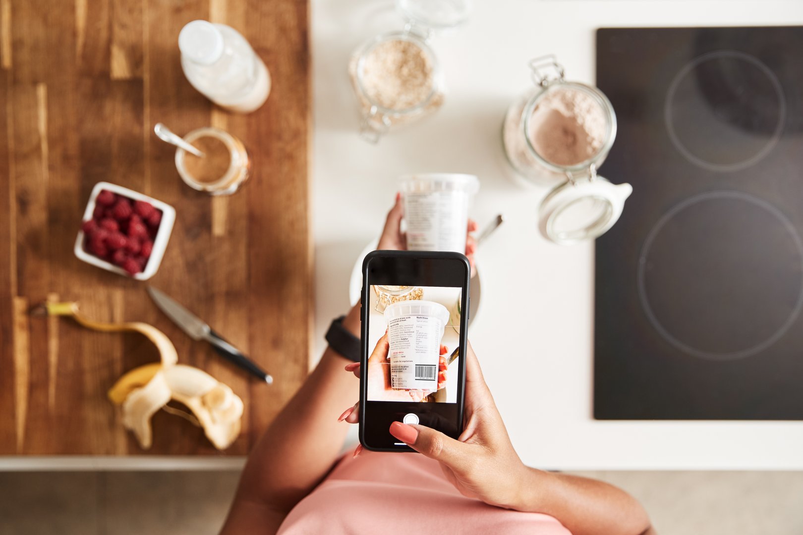 Person photographing a yogurt container with a smartphone